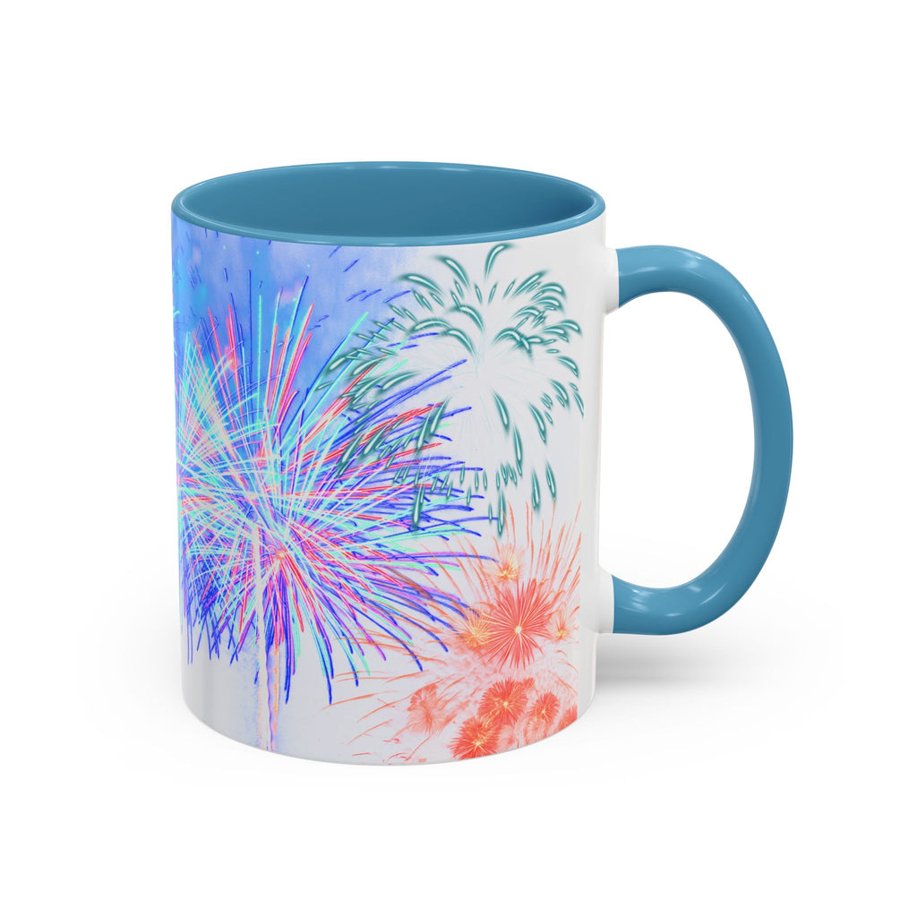 Ceramic coffee mug with light blue rim and handle; white body with colorful fireworks print.