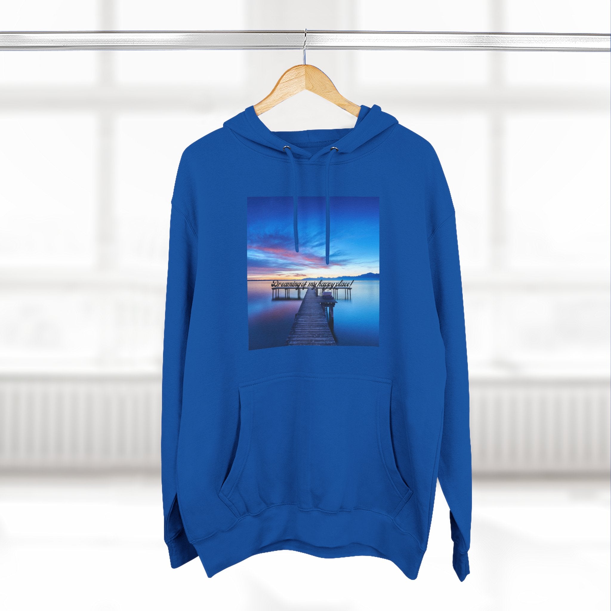 Blue pullover hoodie with hood and front pocket, featuring a dock landscape graphic