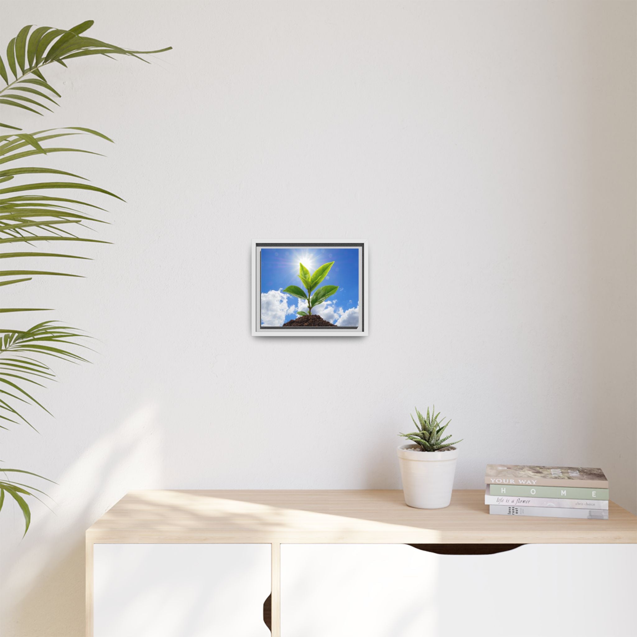 Framed sprouting plant canvas with green leaves and sky background in a light frame