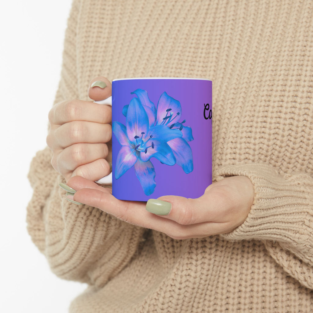 Purple gradient ceramic mug with blue flower graphic, held in hand