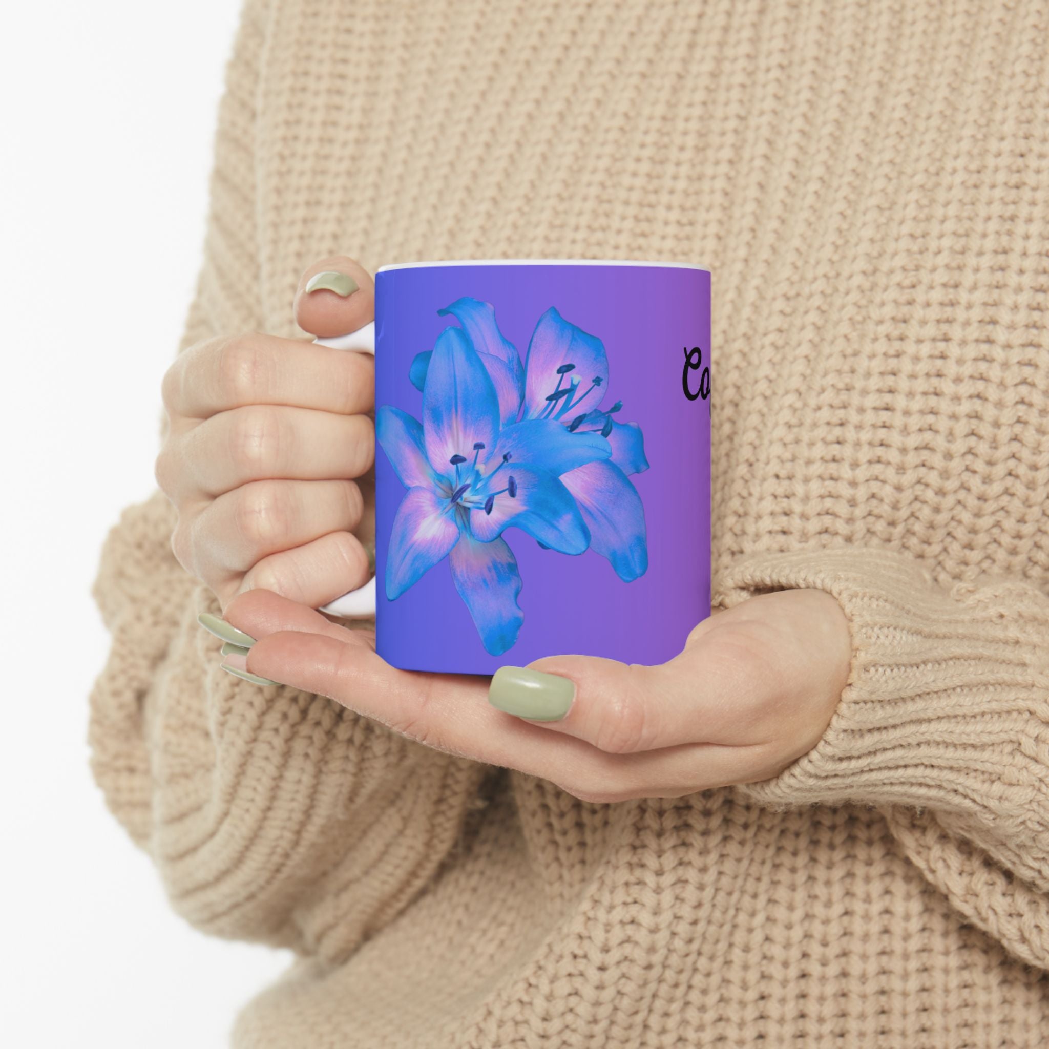Purple gradient ceramic mug with blue flower graphic, held in hand