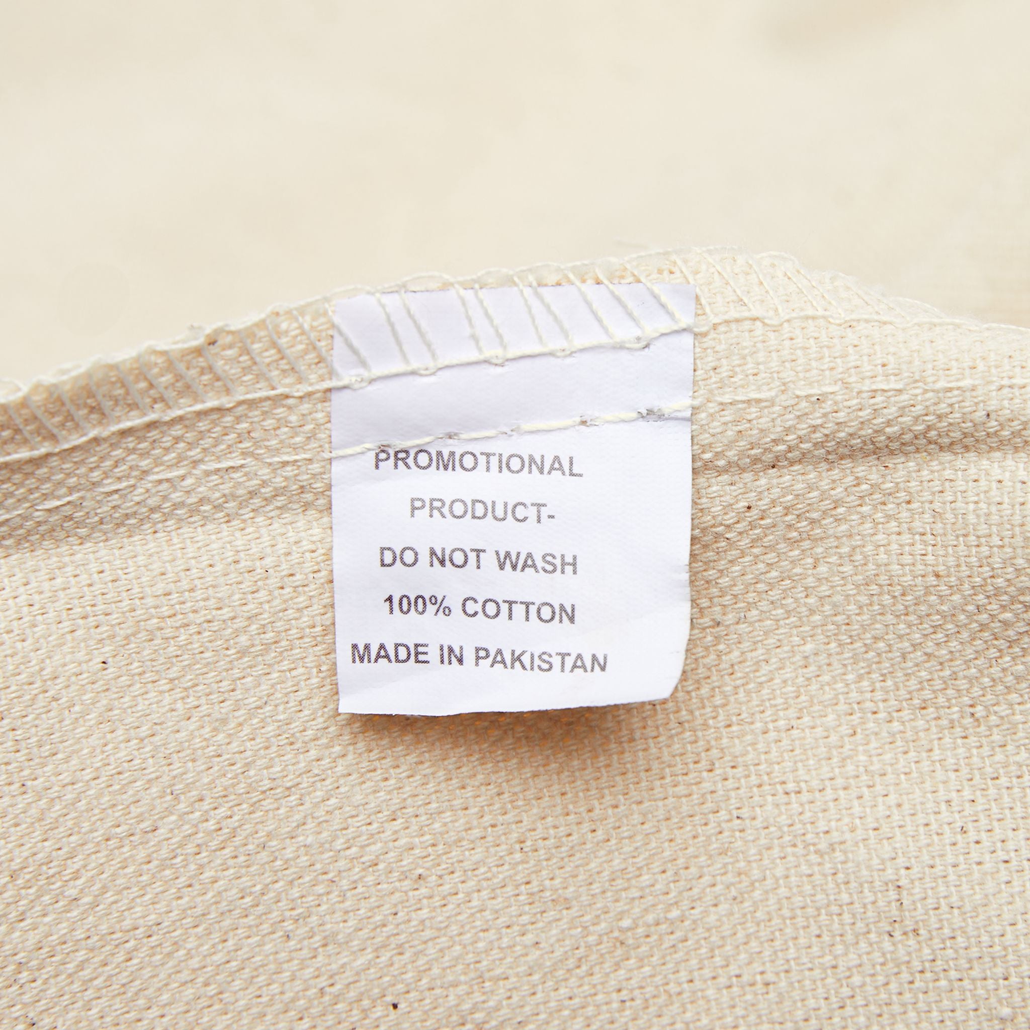 Tote bag care label: DO NOT WASH, 100% COTTON, MADE IN PAKISTAN