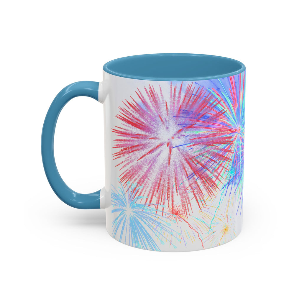 Ceramic coffee mug with light blue rim and handle; colorful fireworks burst print on white body.