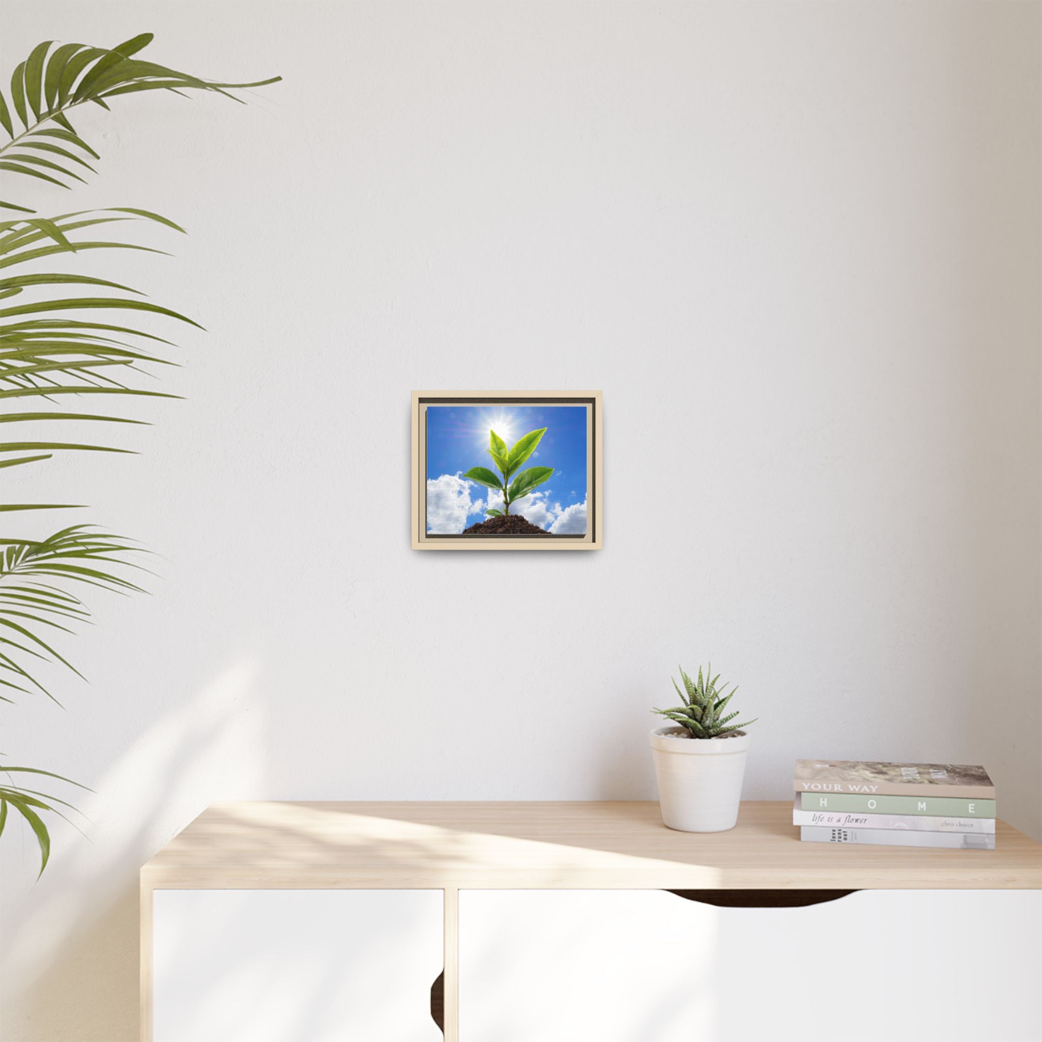 Small framed sprouting plant wall art on light wall, green leaves with tan frame