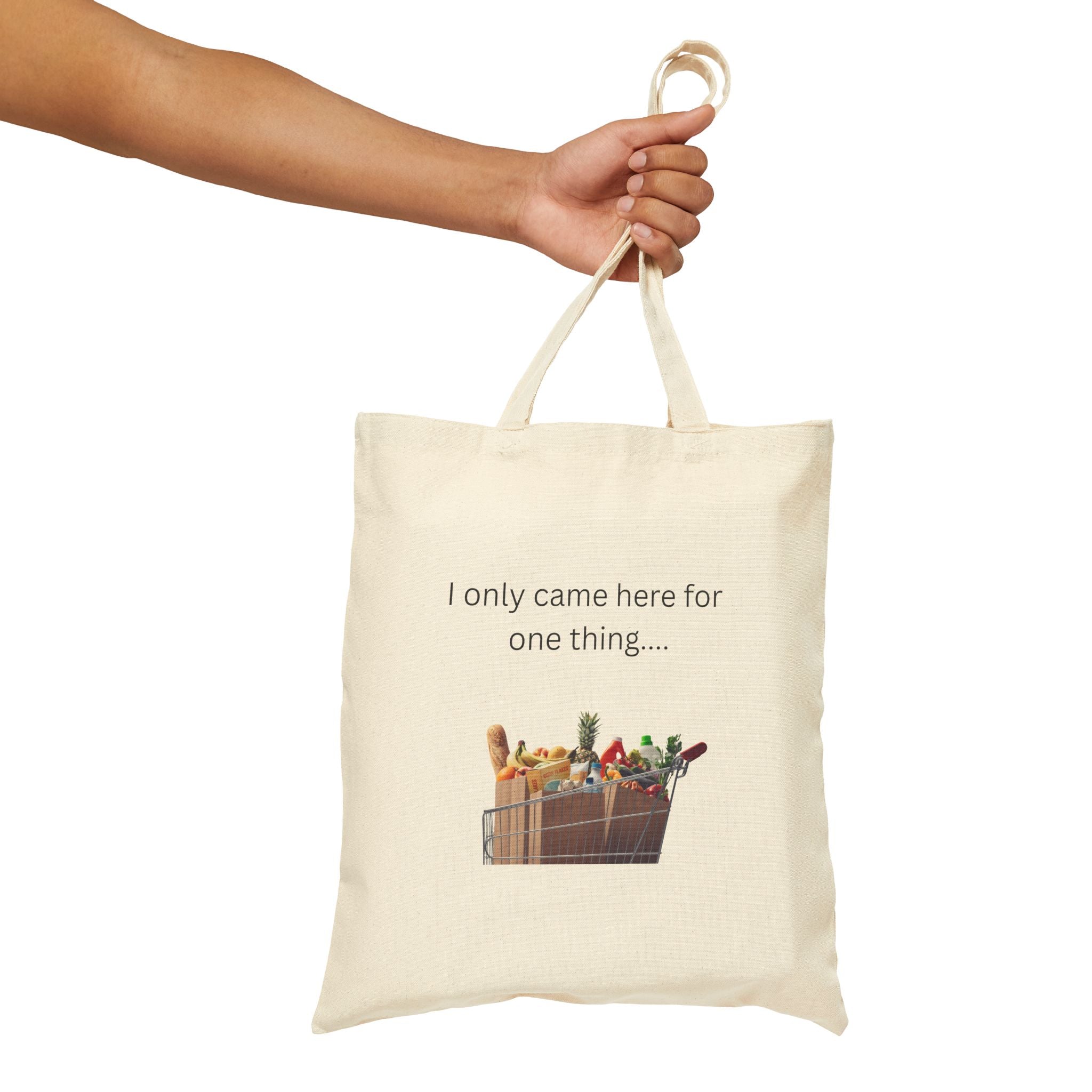 Natural canvas grocery tote bag held by handles, 'I only came here for one thing' print