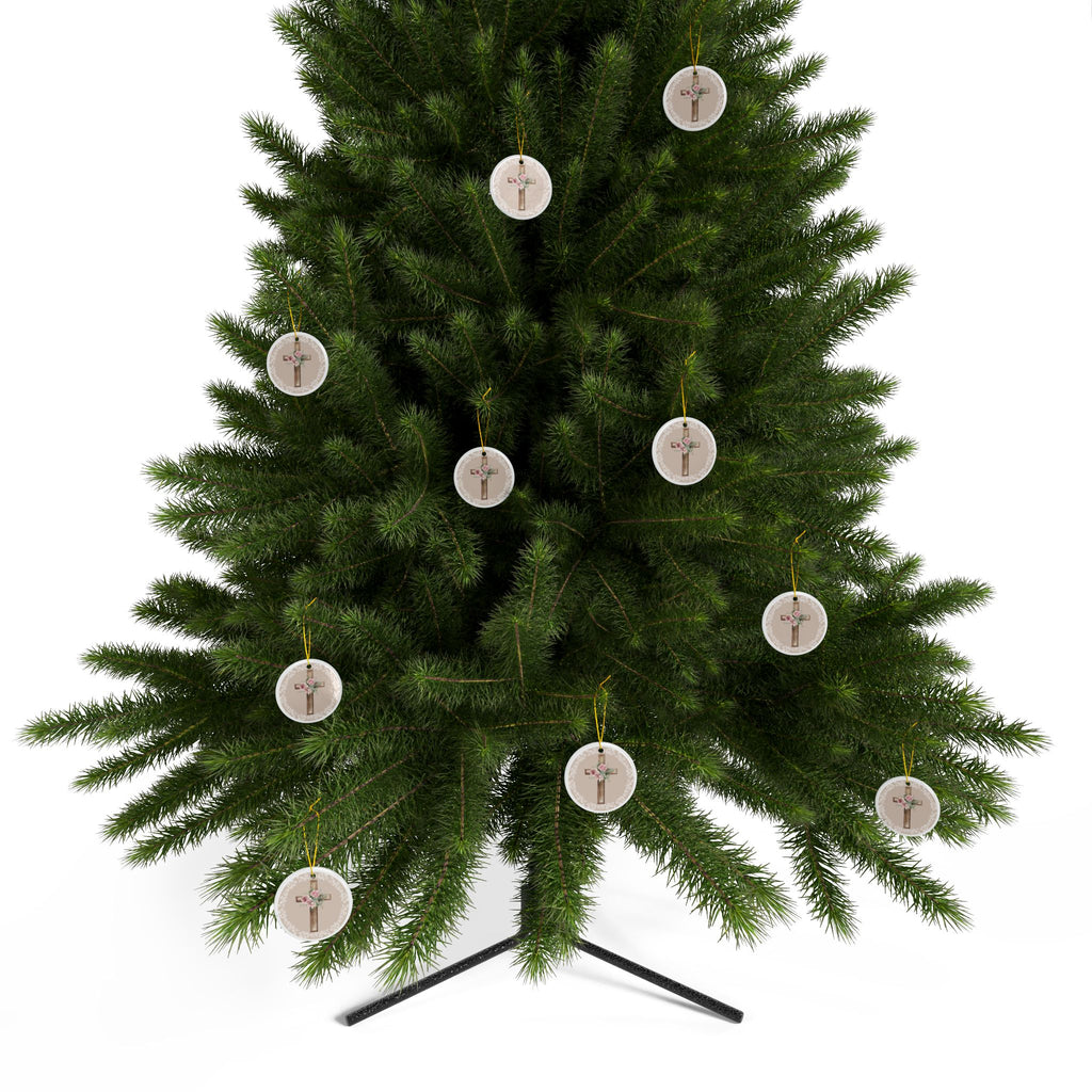 Round ceramic cross ornaments with floral bouquet on wood cross hanging from a tree